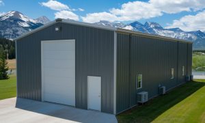30x60 red iron steel building with dark gray siding, a tall roll-up door, and a mountain backdrop, ideal for storage or workshops