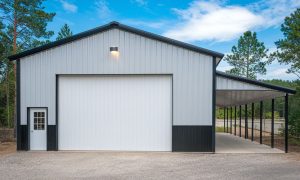 30x60 farm shop metal building with an attached lean-to, black and white steel siding, a roll-up door, and a side entry, set in a wooded area