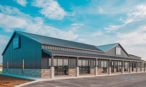 35x70 retail metal building with black steel siding, stone wainscoting, large storefront windows, and a paved parking lot in Chicago IL