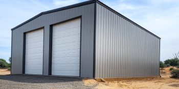 40x40 metal building garage workshop combo with two white overhead doors, gray steel siding, and black trim on a gravel pad