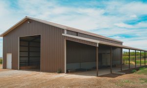 40x60 metal building / barn outbuilding with brown steel siding, open lean-to shelter, and wide entry for livestock or equipment