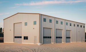 50x75 commercial metal building with beige siding, four tall bay doors, and multiple windows, in a commercial business park in Los Angeles