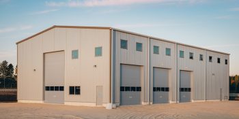 50x75 commercial metal building with beige siding, four tall bay doors, and multiple windows, in a commercial business park in Los Angeles