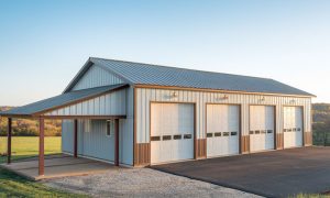 Garage metal building with four parking bays in white and brown, a covered lean-to, and a paved driveway in a rural setting