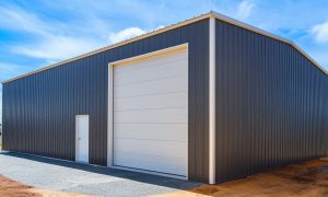 30x40 metal building garage workshop with dark steel siding and a side entry, set on a gravel lot