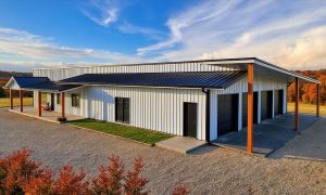 Large single level barndominium with attached four car garage in white