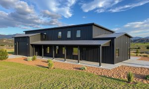 Modern shed roof barndominium in black and gray with an attached garage