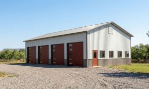 A large 4-bay metal garage with modern overhead doors in gray, black and red