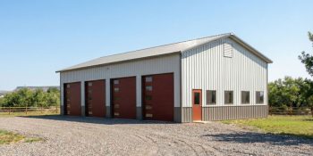 A large 4-bay metal garage with modern overhead doors in gray, black and red