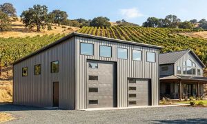 A modern motorhome garage with a single slope roof in gray and black set in a California vineyard