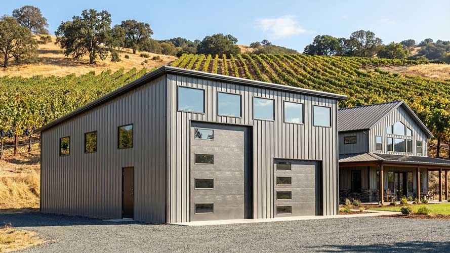 A modern motorhome garage with a single slope roof in gray and black set in a California vineyard