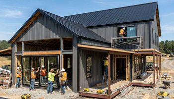 Custom windows and doors being added to a barn house under construction