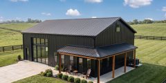 A 30x40 metal building in black with wrap around porch located in rural Kentucky