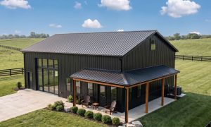 A 30x40 metal building in black with wrap around porch located in rural Kentucky