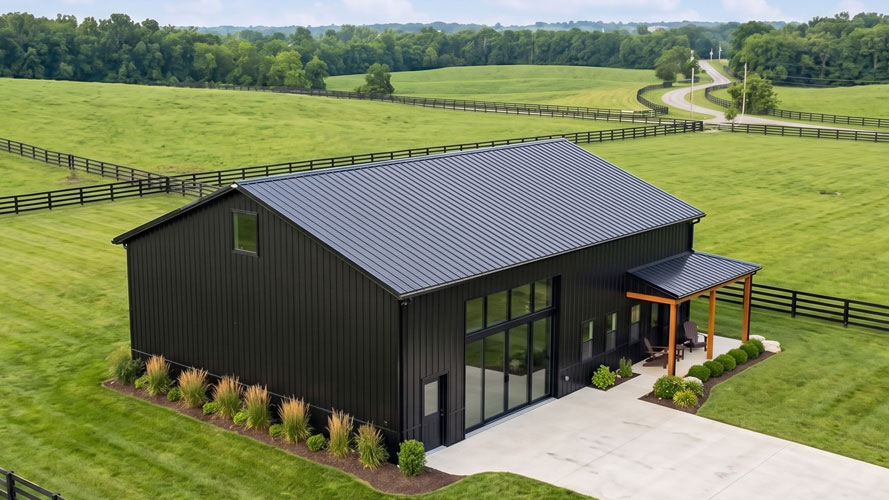 An aerial shot of a A 30x40 metal building in black with wrap around porch located in rural Kentucky