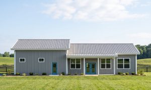 The Hollow 30×70 barndominium front elevation (south on the plan), photoreal render: 3:12 gable, the 26 foot front porch